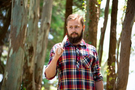Portrait of an attractive young lumberjack who walks through the woods in search of the treeの写真素材