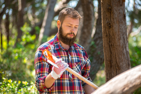 Portrait of an attractive young lumberjack who walks through the woods in search of the treeの写真素材