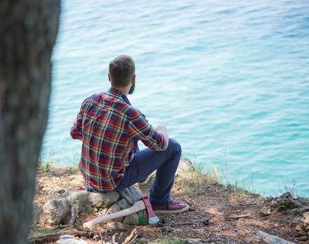 Portrait of an attractive young lumberjack who is resting after cutting a treeの写真素材