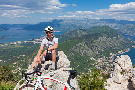 Cyclist on the top of a hill sitting on a background of the bay and the seaの写真素材