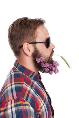 Portrait of handsome man with beard of clover flowers isolated on whiteの写真素材