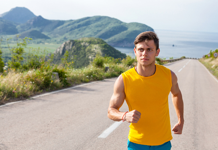 Healthy active man runner running on the empty roadの写真素材