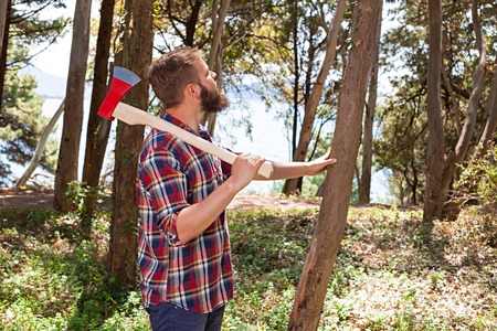Portrait of an attractive young lumberjack who walks through the woods in search of the treeの写真素材