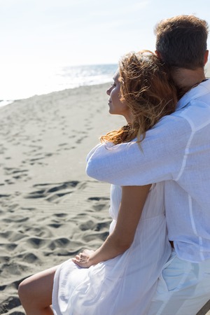 happy couple in love walking on the beach in summer white dressの写真素材