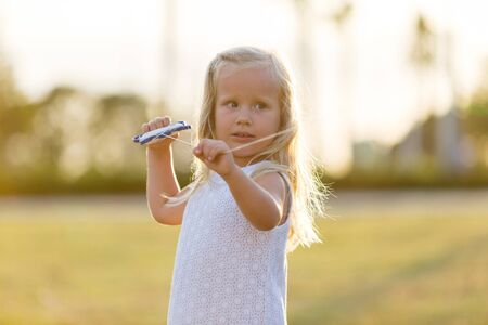 little girl in a white dress flying a kiteの写真素材