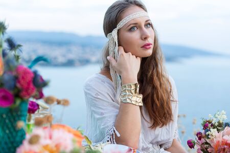 girl with a wedding bouquet boho style, sea backgroundの写真素材