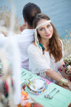 girl with a wedding bouquet boho style, sea backgroundの写真素材