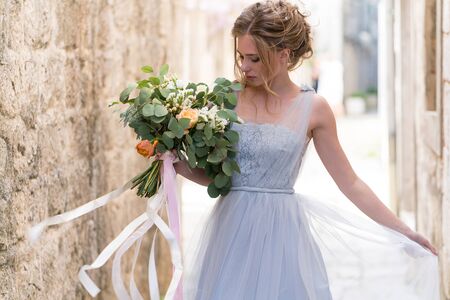Portrait of a young beautiful bride with a wedding bouquetの写真素材