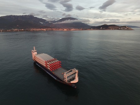 Aerial view of a cargo vessel loaded with rotor blades for wind turbines, taken at sunsetの写真素材