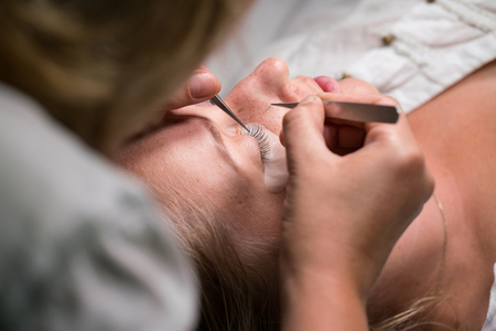 Woman Eye with Long Eyelashes. Eyelash Extension procedure.
