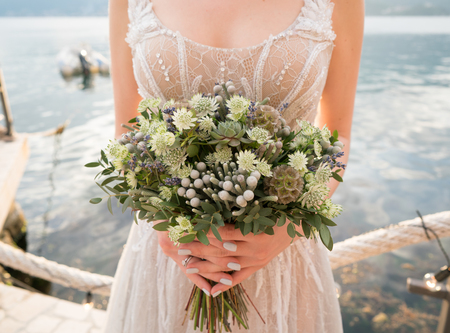 Wedding bouquet in the hands of the bride with lots of greeneryの写真素材