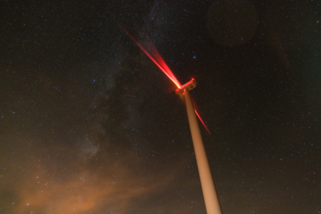 wind turbines generating clean power with milky wayの写真素材