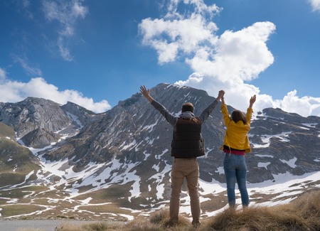 Happy joyful young couple walking on the foothills together.の写真素材