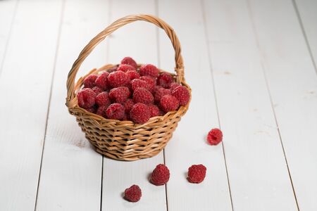 raspberries in the basket on white backgroundの写真素材