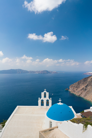 sunset over aegean sea with view to Virgin Mary Catholic Church Three Bells of Fira, Santorini.の写真素材