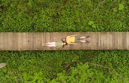 couple of lovers lying on a wooden bridge in the forestの写真素材