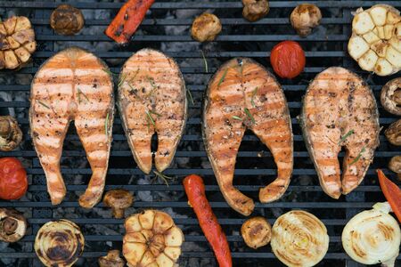 grilled salmon steaks with vegetables on the grill, outside