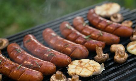 grilled sausages with vegetables on the grill, outdoors