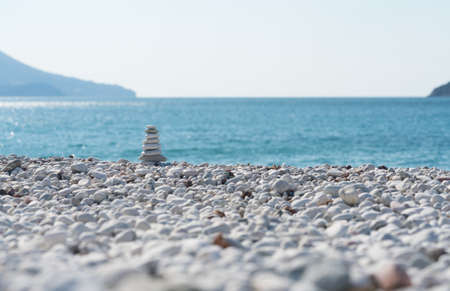 Zen pyramid on a pebble beach on a sunny dayの写真素材