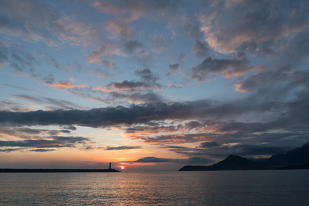 lighthouse at sunset and magnificent sky with textured cloudsの写真素材