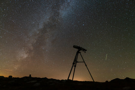 telescope on a tripod against the background of the starry skyの写真素材