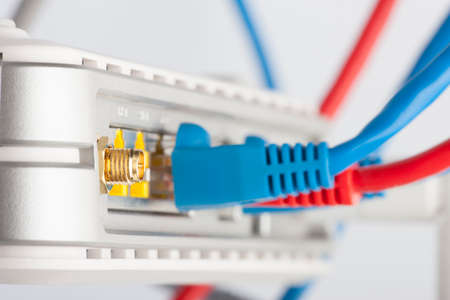 Modem router network hub with cable connecting. Bright blue and red cables and connectors.