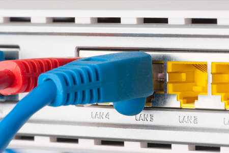 Modem router network hub with cable connecting. Bright blue and red cables and connectors.