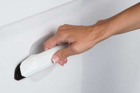 Woman hand on open the new white car door background Close-upの写真素材