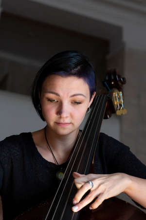 Young positive brunette playing double bassPortrait