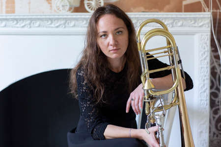 Portrait of a young woman trombonist Young Female Musician Playing Tromboneの写真素材