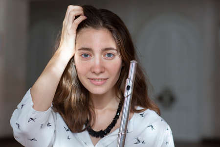 Beautiful young woman with flute Genre portrait of young beautiful girlr Close-upの写真素材