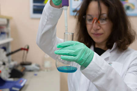 Female Laboratory Scientist Examining Sample In Test Tube Close-up