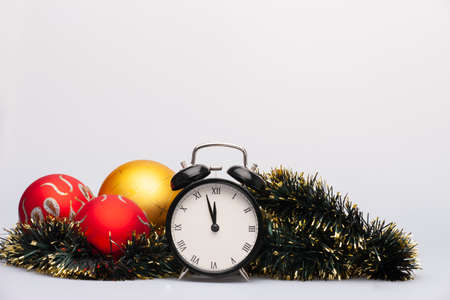 An alarm clock, tinsel, gold and red baubles for christmas decoration