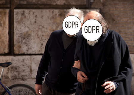 GDPR - two elderly people, talking, walking down the street their faces are covered with the...