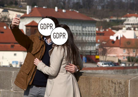 GDPR - a couple of young people take selfies, their faces are covered with the inscription General Data Protection Regulation. Cyber security and privacy. Close-upの写真素材