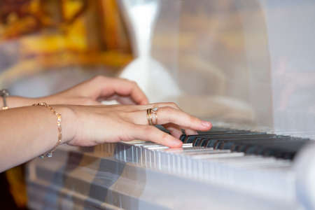 closeup musician hands playing piano on piano keyboard. abstract musical backgroundの写真素材