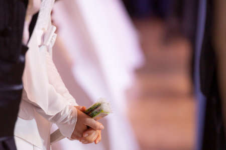 Wedding theme, holding hands newlyweds White gloves Close-up