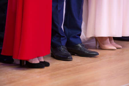 Kind of women's legs in stylish shoes and beautiful ball gowns on the background. Close-upの写真素材