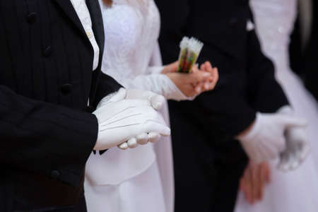 Wedding theme, holding hands newlyweds White gloves Close-upの写真素材