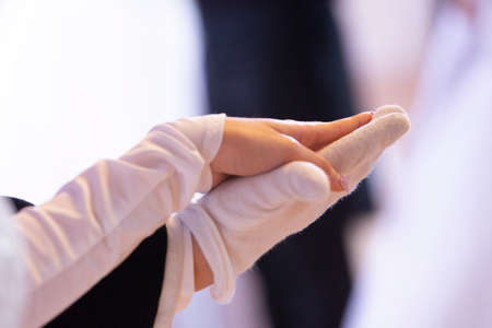 Wedding theme, holding hands newlyweds White gloves Close-upの写真素材