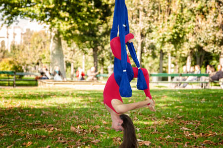 Young woman practicing fly yoga asana outdoors. Health, sport, yoga concept Limited depth of fieldの写真素材