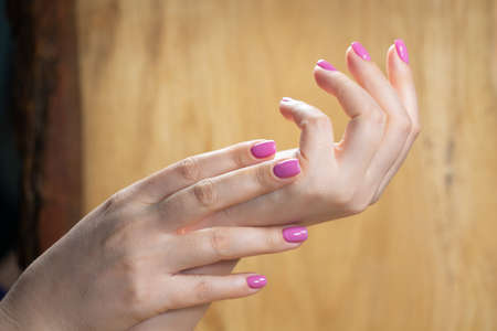 Beauty woman hands with pink fashion manicure. close up