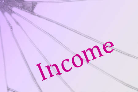 The text Income on the broken glass. Financial crisis. Backgroundの写真素材