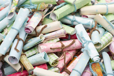 Pile of small paper scrolls White scrolls tied with blue and pink ribbon. Future prediction, advice...