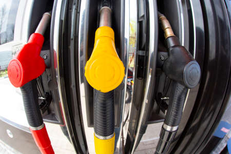 Close-up fuel nozzles on petrol and diesel fuel. Gas station pump. Man refueling gasoline with fuel...