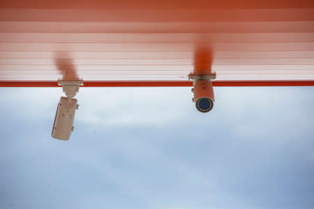 CCTV security cameras on pole on blue sky with white clouds background Limited depth of field. Blurred imageの写真素材