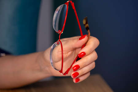 Luxury short manicure Red nails design. female hand holding glasses Limited depth of field Close-upの写真素材