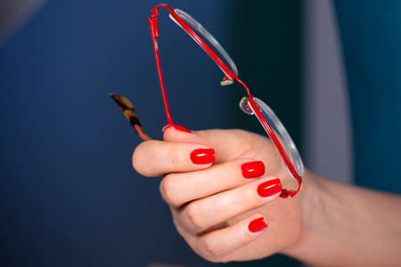 Luxury short manicure Red nails design. female hand holding glasses Limited depth of field Close-upの写真素材