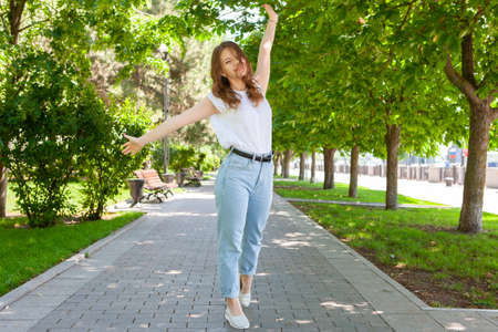 Trendy Hipster Girl Walking in the Park. Modern Youth Lifestyle Concept. Portraitの写真素材