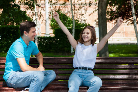 beautiful young couple sitting on a bench in the park. Portraitの写真素材